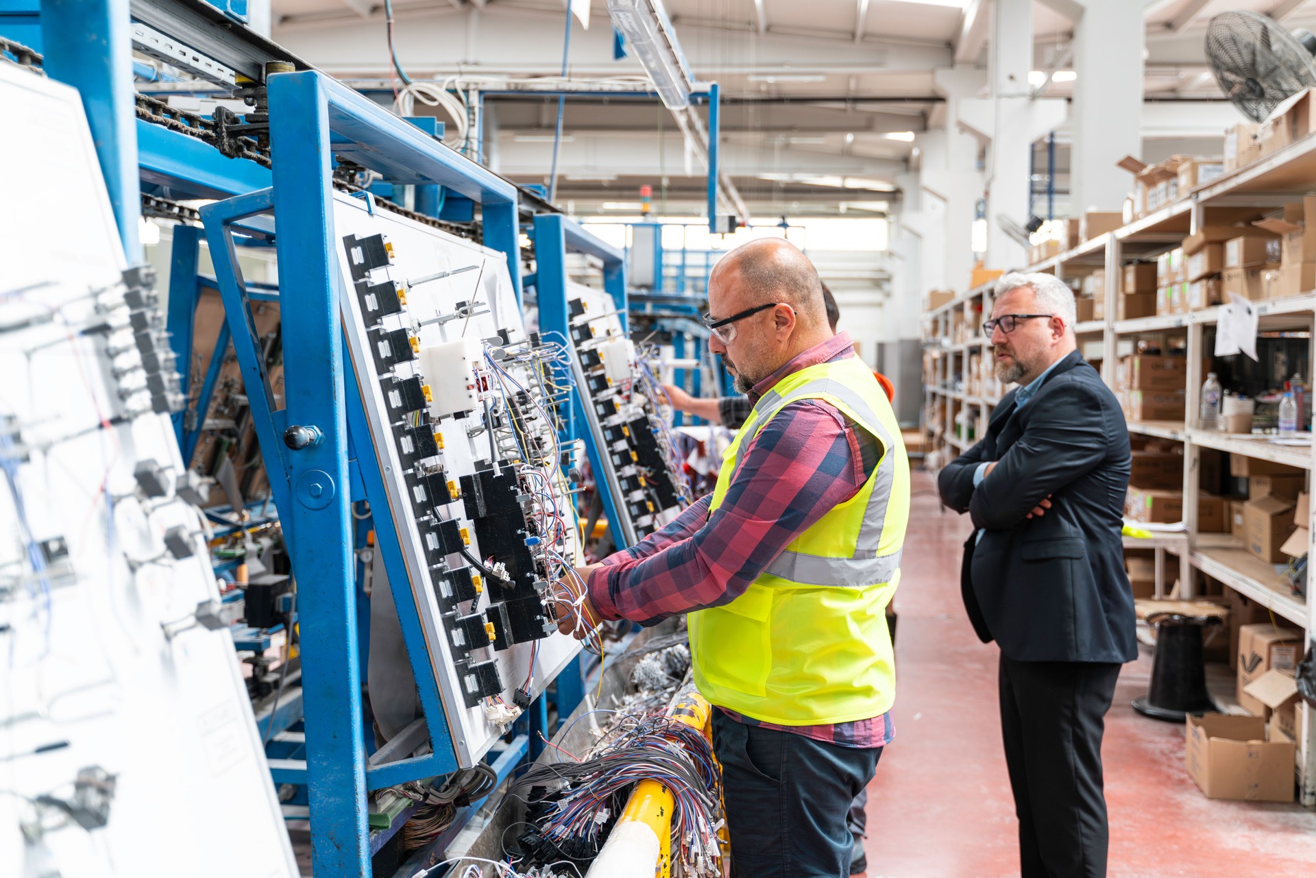 Mature manager and automotiv cable factory employees working together to get the job done.